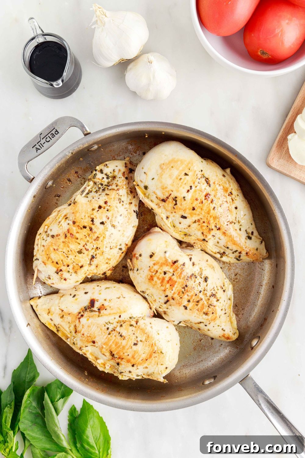 Partially cooked Caprese Stuffed Chicken in a skillet, showing a golden-brown sear