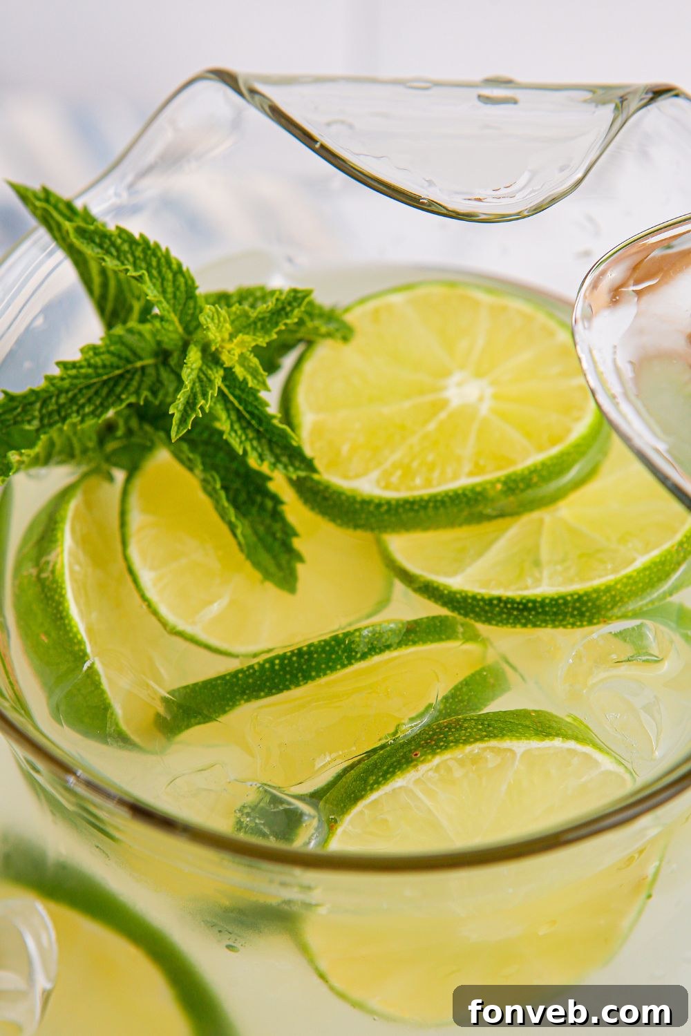 lime aid drink in a pitcher with mint and lime slices