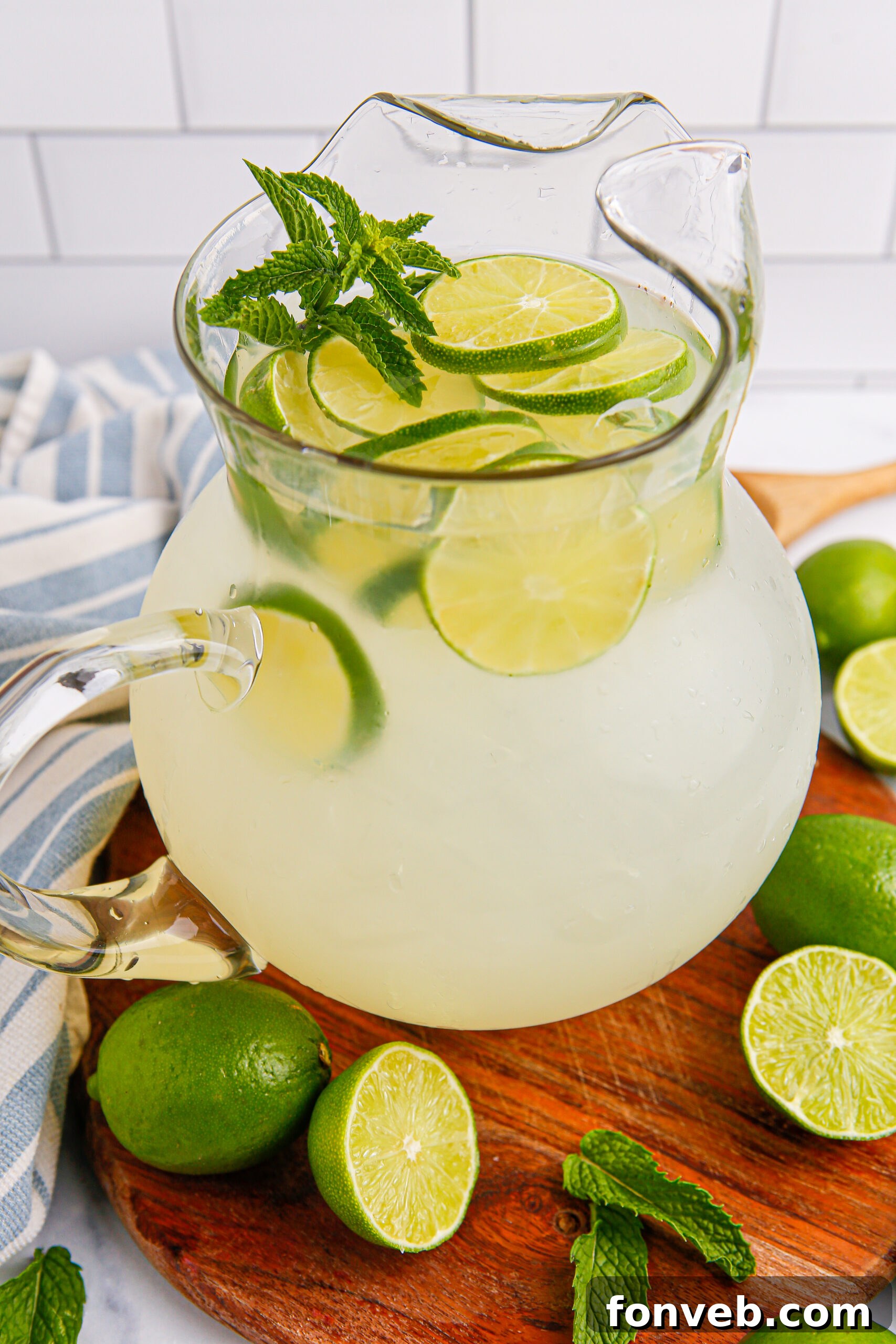 overhead look of pitcher with limeade in it, and scattered limes on table