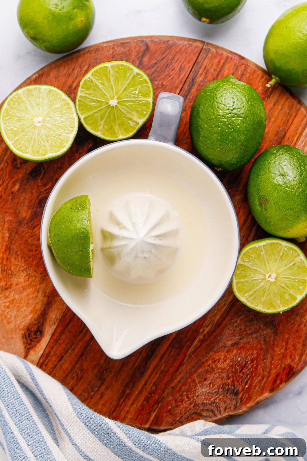 limes around table and a juicer showing limes being juiced