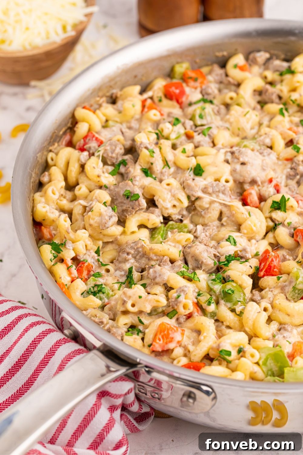 Creamy Philly Cheesesteak Pasta 3 Philly Cheesesteak Pasta in a pan with a red striped towel on table by it