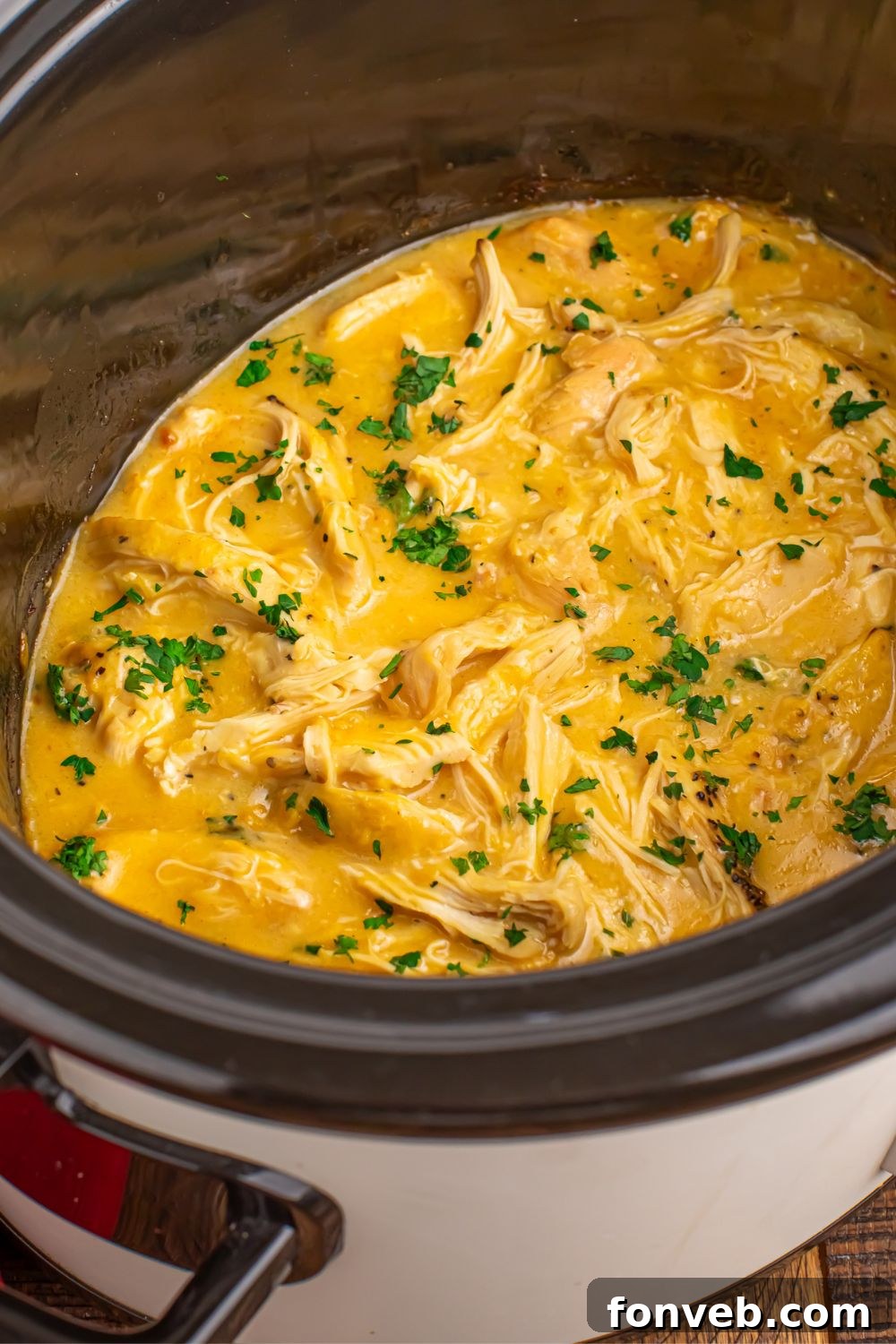 side view of a Crock Pot with Chicken and Gravy it in sitting on table
