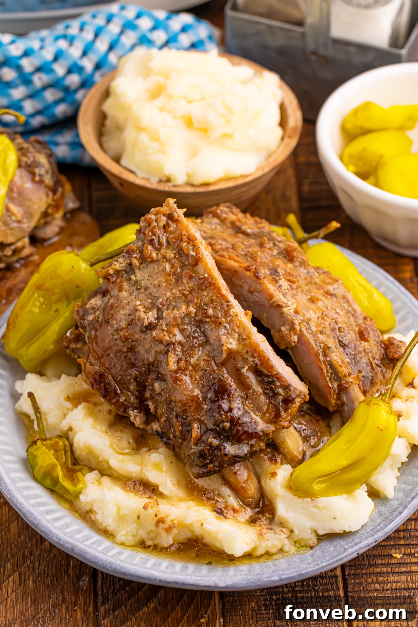 Slow Cooker Mississippi Ribs on a white plate sitting on top of mashed potatoes