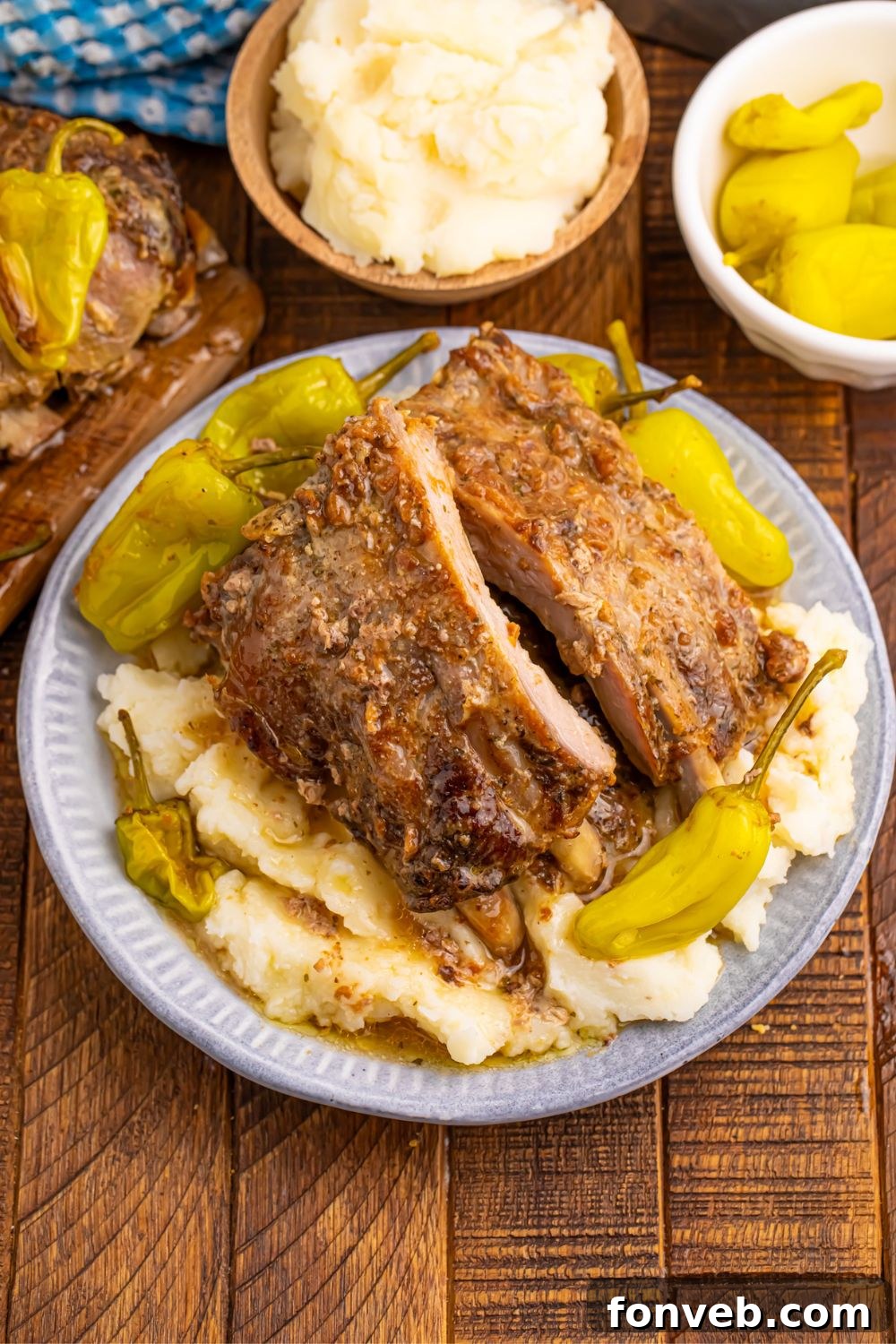 Slow Cooker Mississippi Ribs on a plate with potatoes, and then small bowls with ingredients used to make the pork ribs