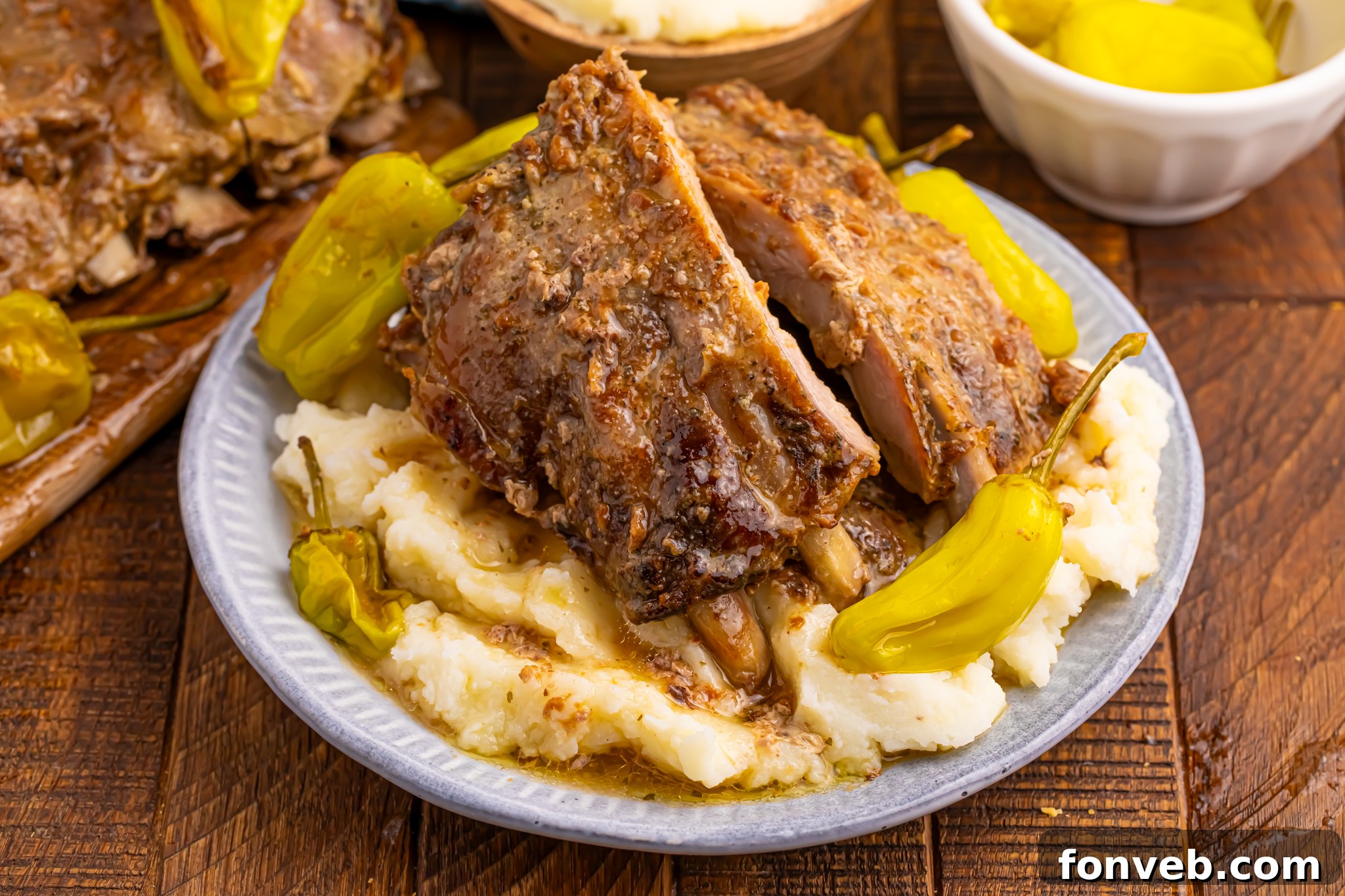 Slow Cooker Mississippi Ribs on a white plate sitting on top of mashed potatoes