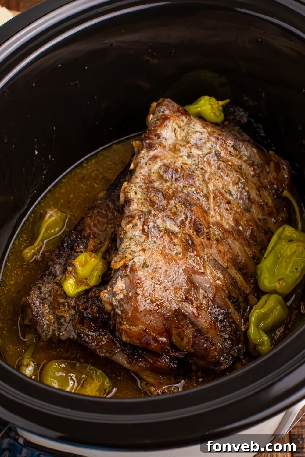 Slow Cooker Mississippi Ribs in a slow cooker with peppers and juice around them