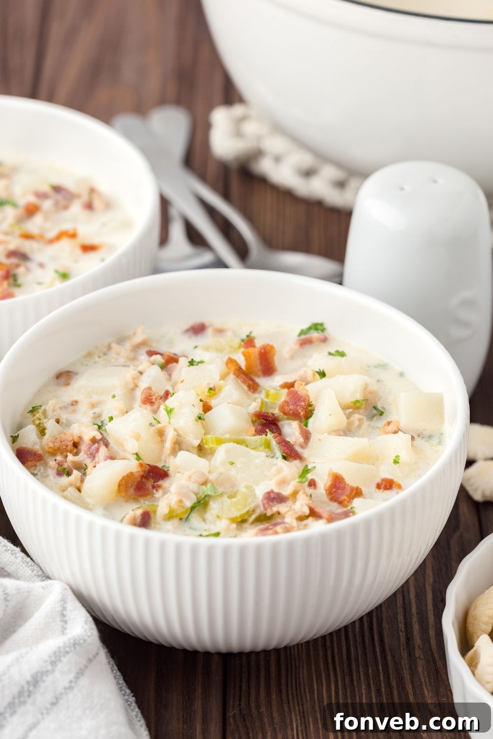 bowls New England Clam Chowder in bowls with salt and pepper shakers by it sitting on table 