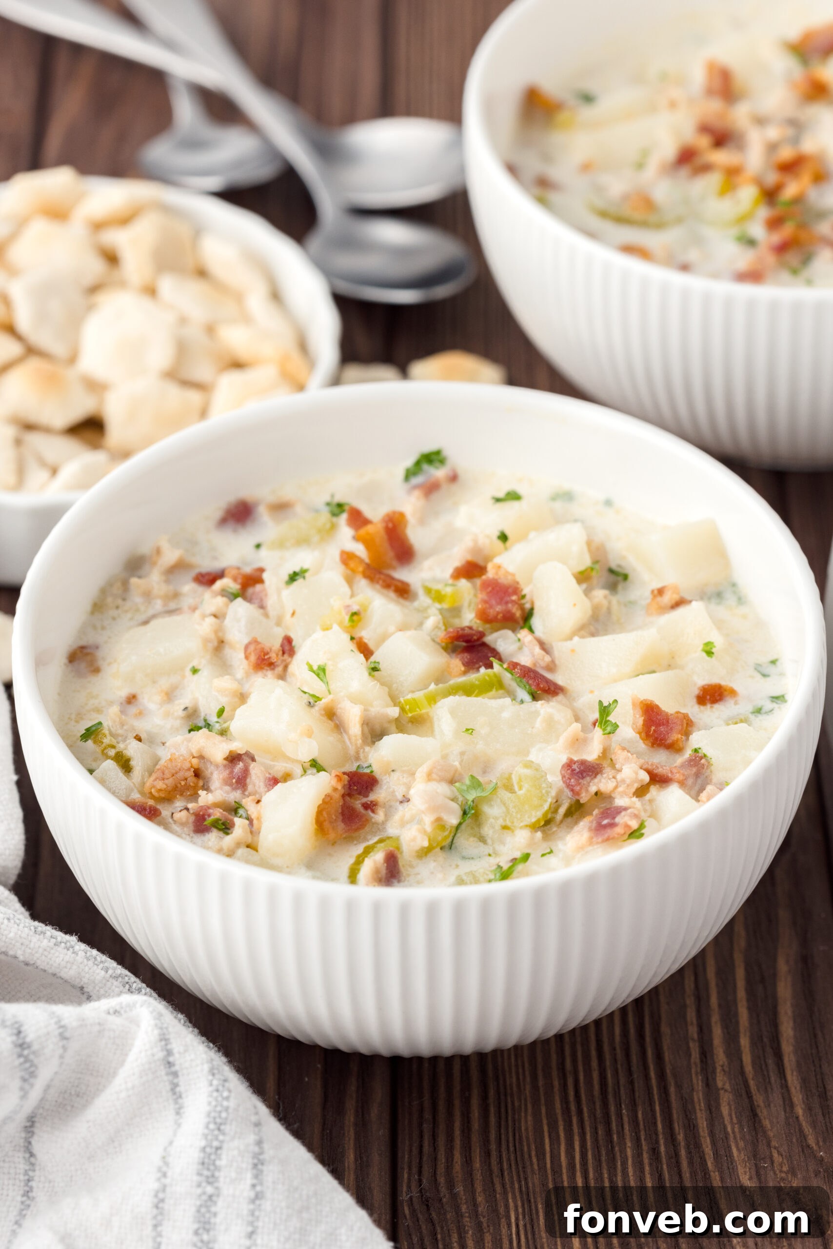 Clam chowder in a white bowl on a wooden table