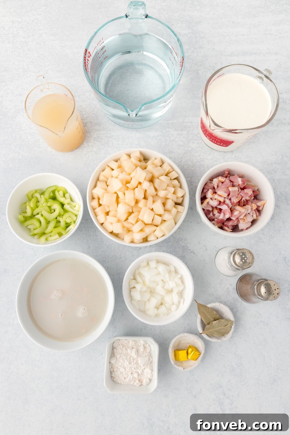 ingredients for clam chowder sitting in small bowls on table to show all the ingredients