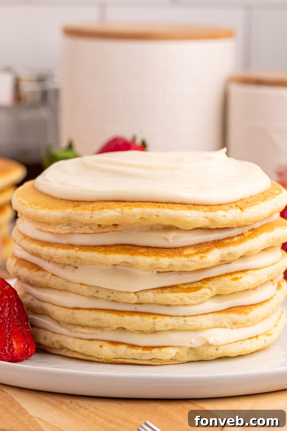 Cooked pancakes with a generous layer of cream cheese cheesecake spread on top of each.