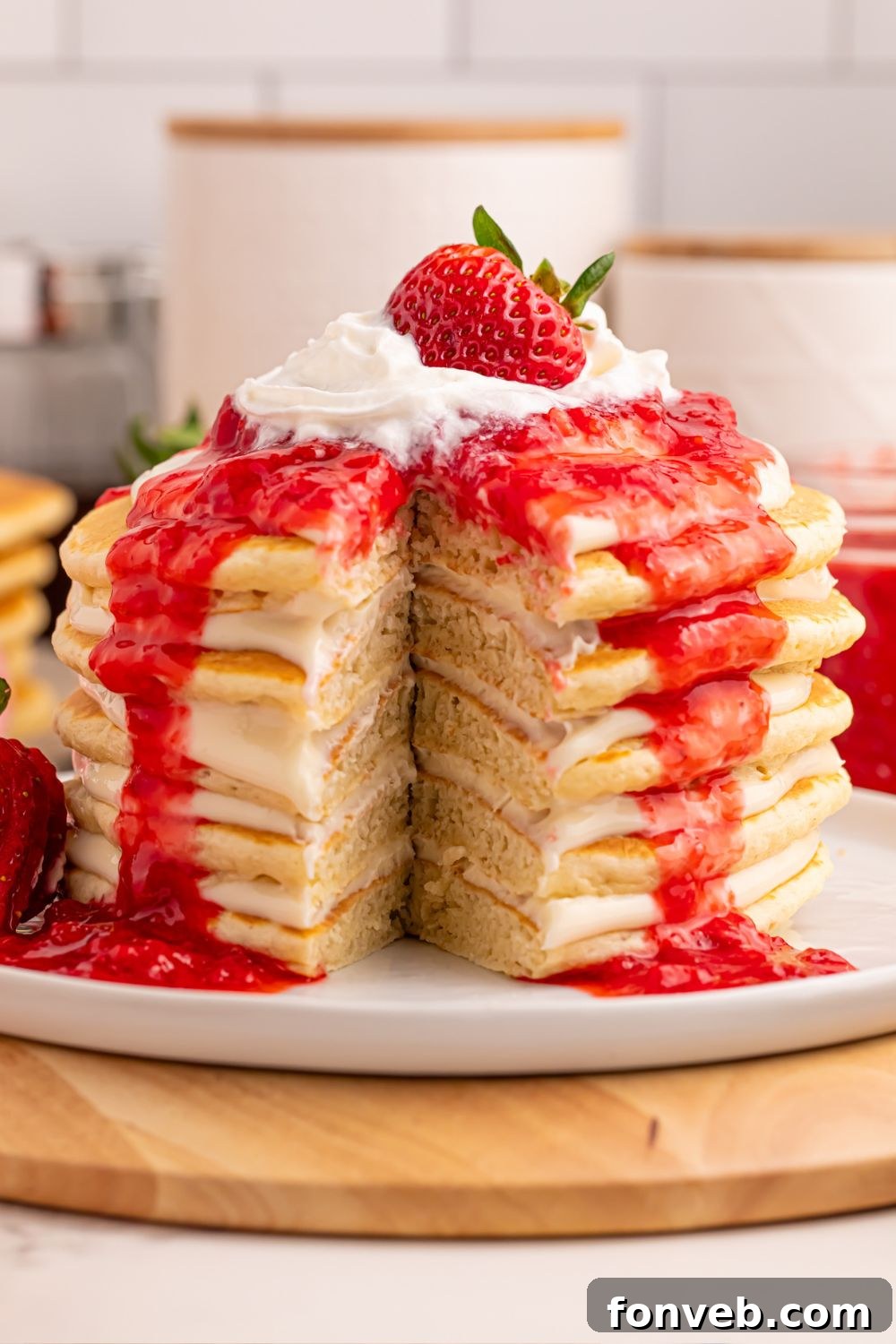 Strawberry Cheesecake Pancakes stack cut open to reveal layers of fluffy pancake and creamy cheesecake filling.