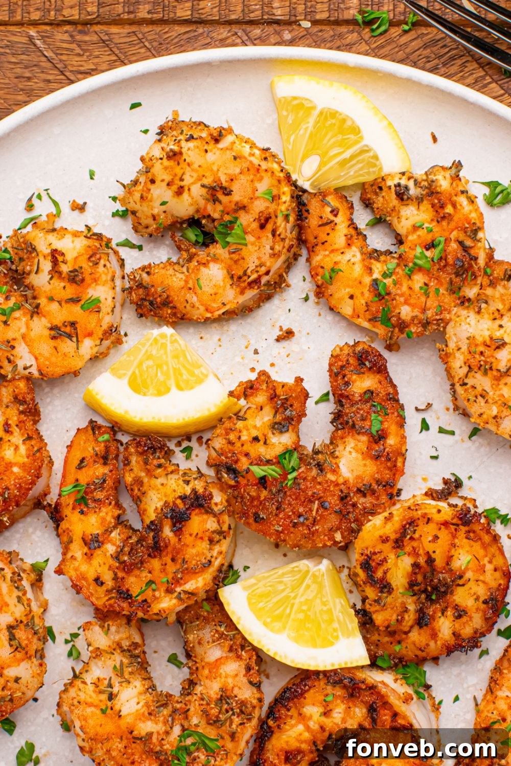 Cajun Grilled Shrimp spread out on a plate with sliced lemon on it 