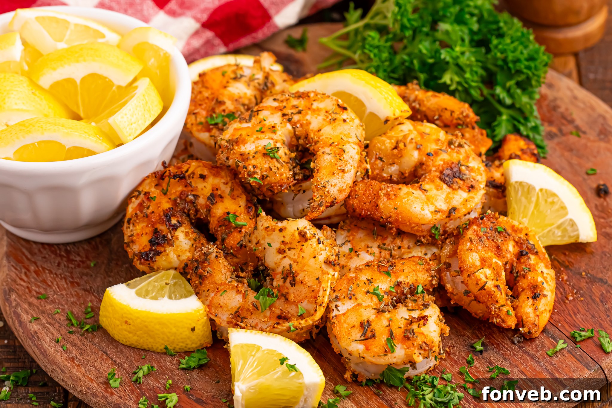 bowl of lemons, Cajun shrimp, herb garnish around a pile of shrimp