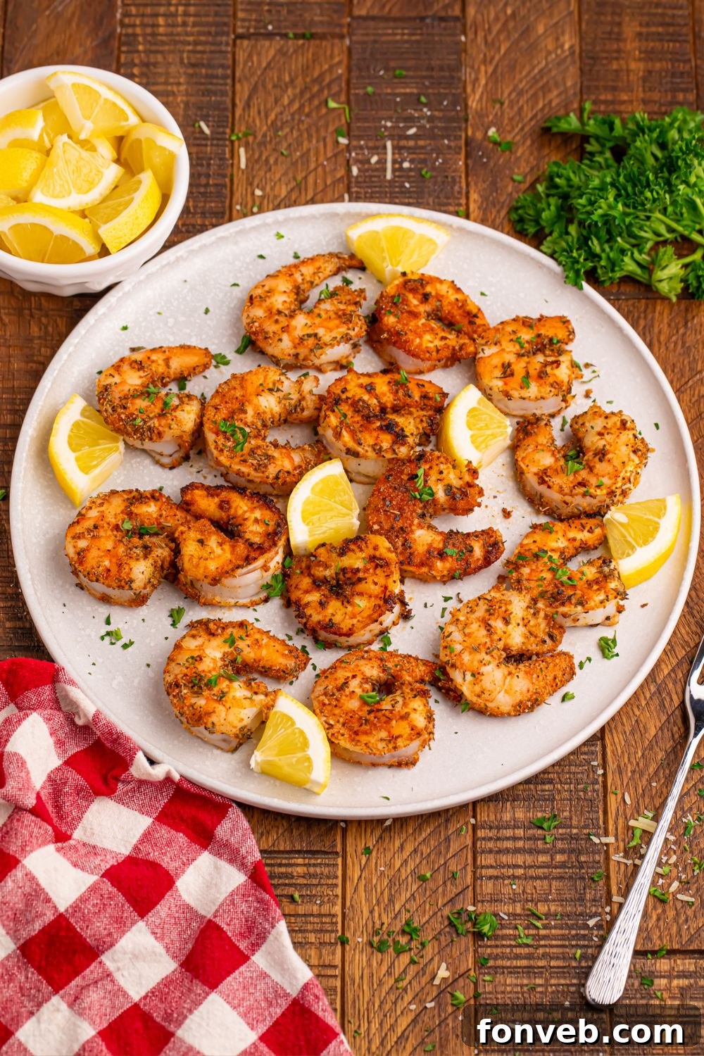 Cajun Grilled Shrimp on a plate with slices of lemons around it 