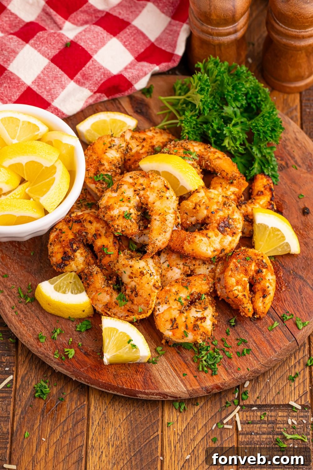 Cajun Grilled Shrimp on a wooden counter with a bowl of lemons on the side 
