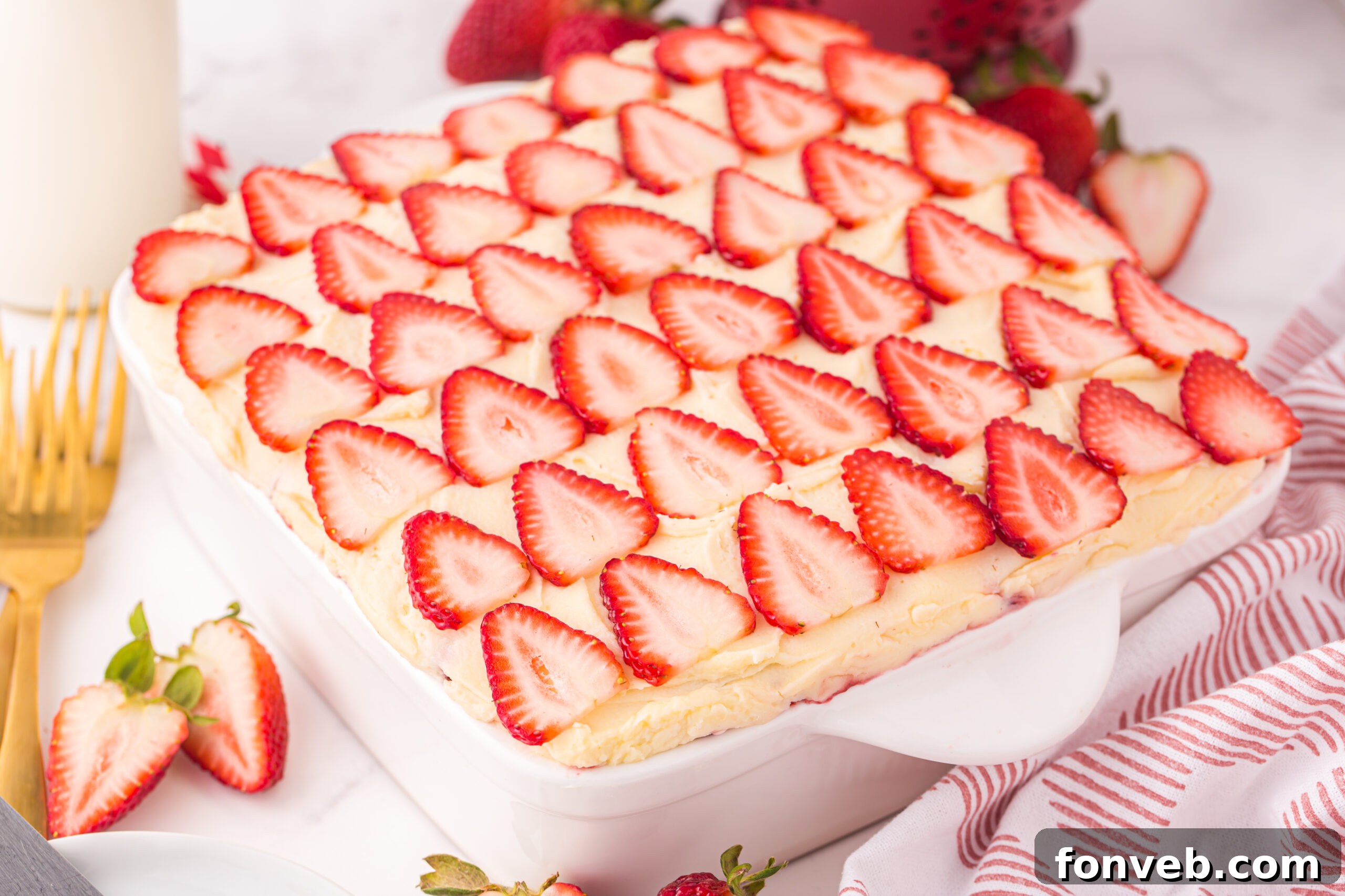 Strawberry Tiramisu in a pan on table with a towel behind it 