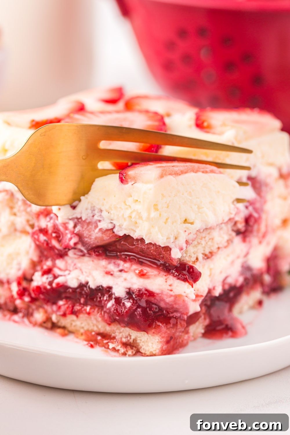 gold fork slicing into a piece of Strawberry Tiramisu