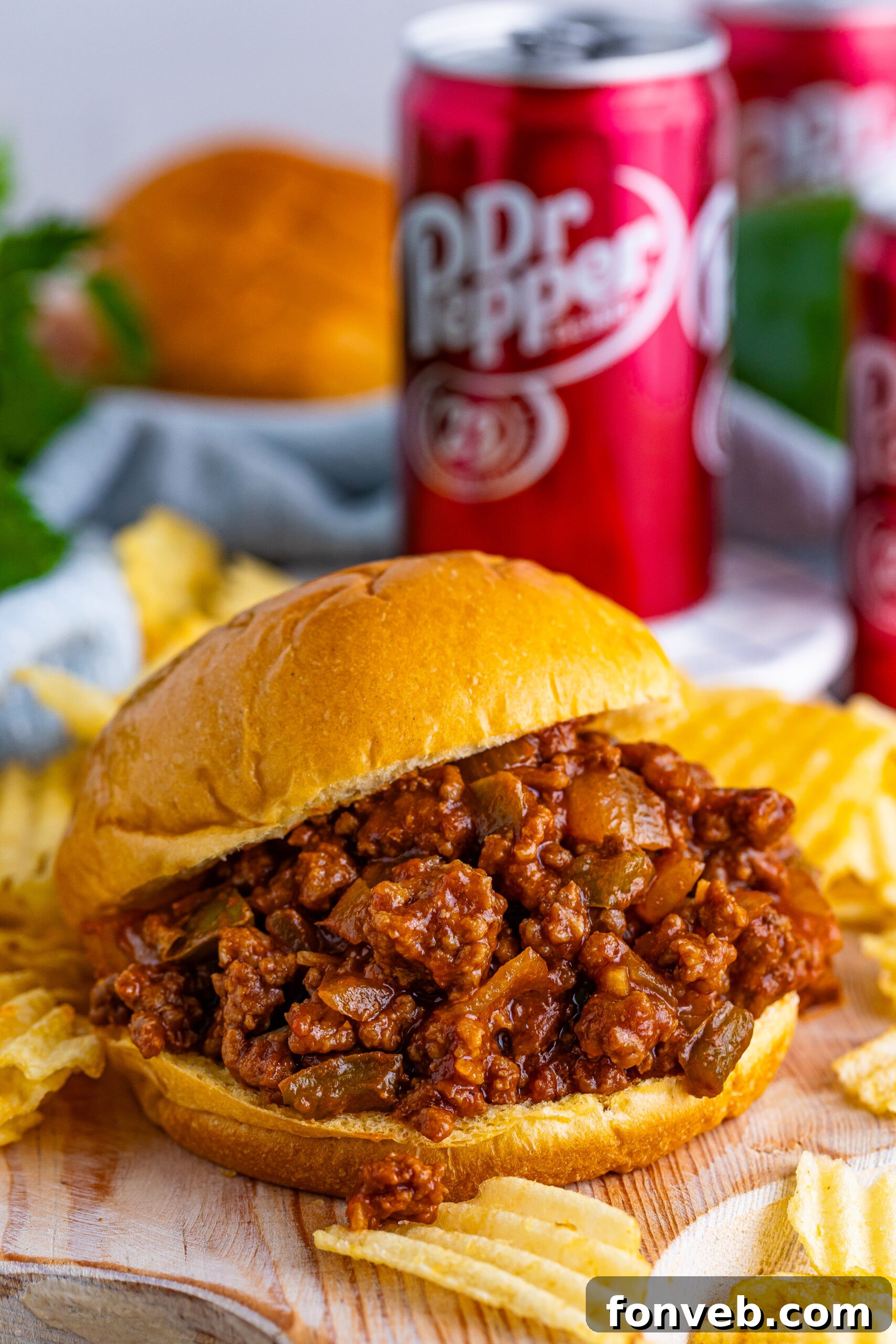 Dr. Pepper Sloppy Joe on table with chips, and can of Dr. Pepper in the back of table