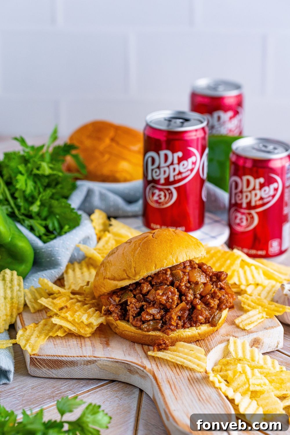 sloppy joes, chips, Dr. Pepper, and fresh herbs around the table
