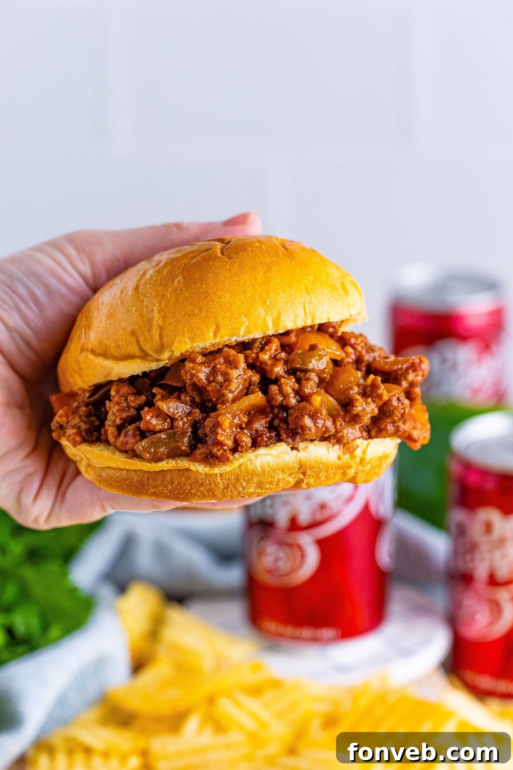 Dr. Pepper Sloppy Joe sandwich being held in a persons hand