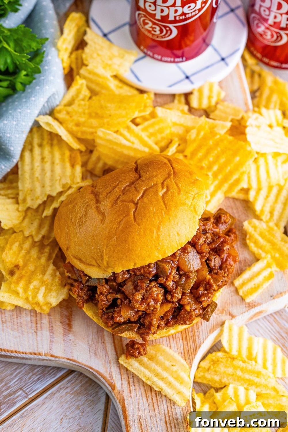 Dr. Pepper Sloppy Joe on table with chips and cans of pop in the background