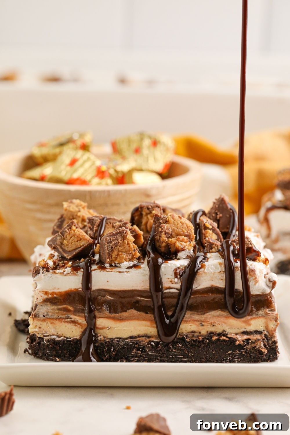 Peanut Butter Chocolate Sweet Stack 20 chocolate sauce being drizzled on top of Reeses Lasagna on plate