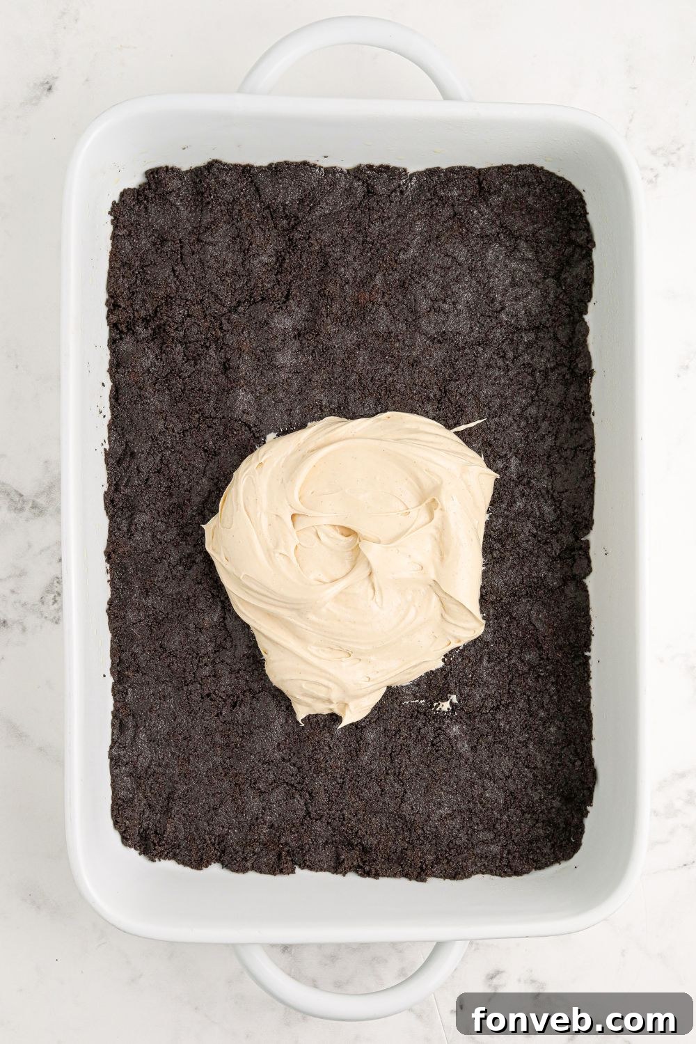 Peanut Butter Chocolate Sweet Stack 9 Reeses Lasagna being assembled. Oreo crust in pan with some cream cheese peanut butter in center