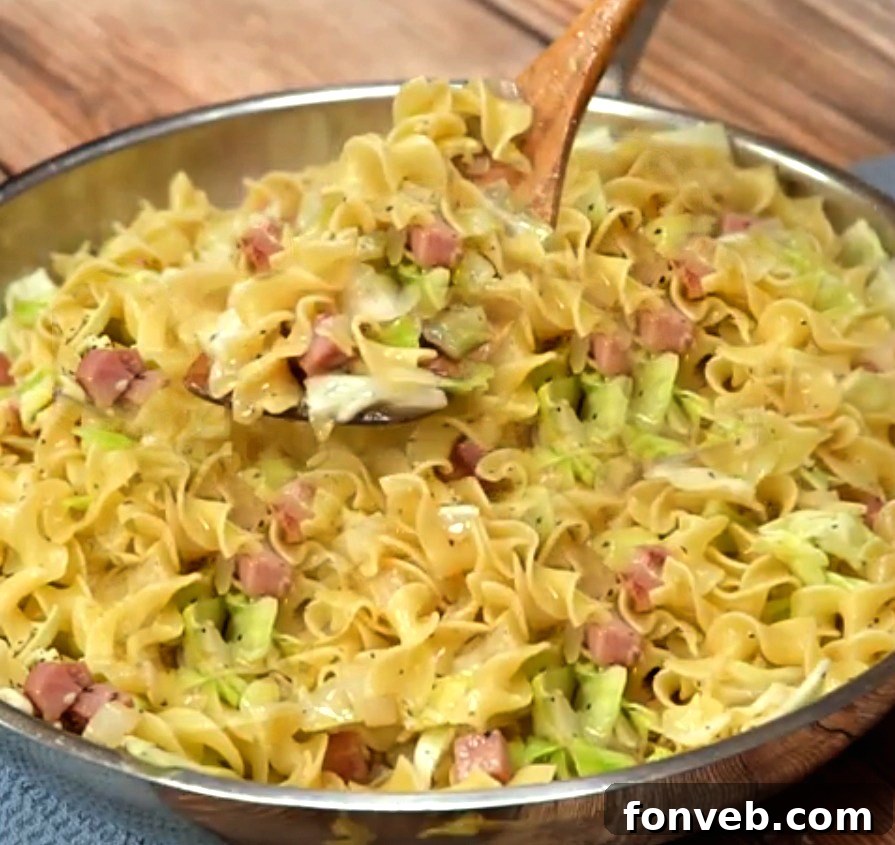 Close-up shot of a steaming plate of Haluski, highlighting the golden-brown cabbage and tender noodles.