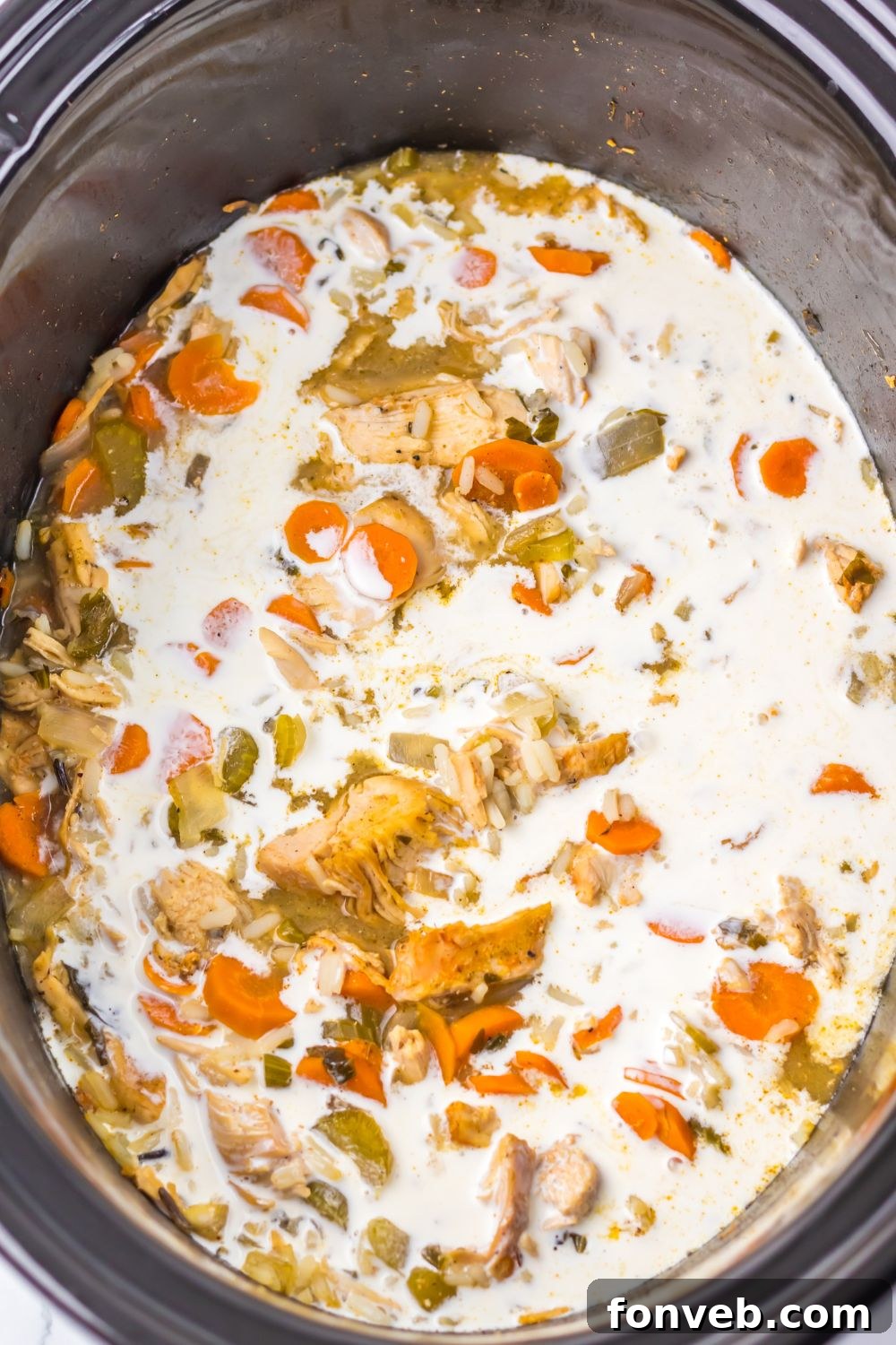 cream being poured into the slow cooker turkey soup