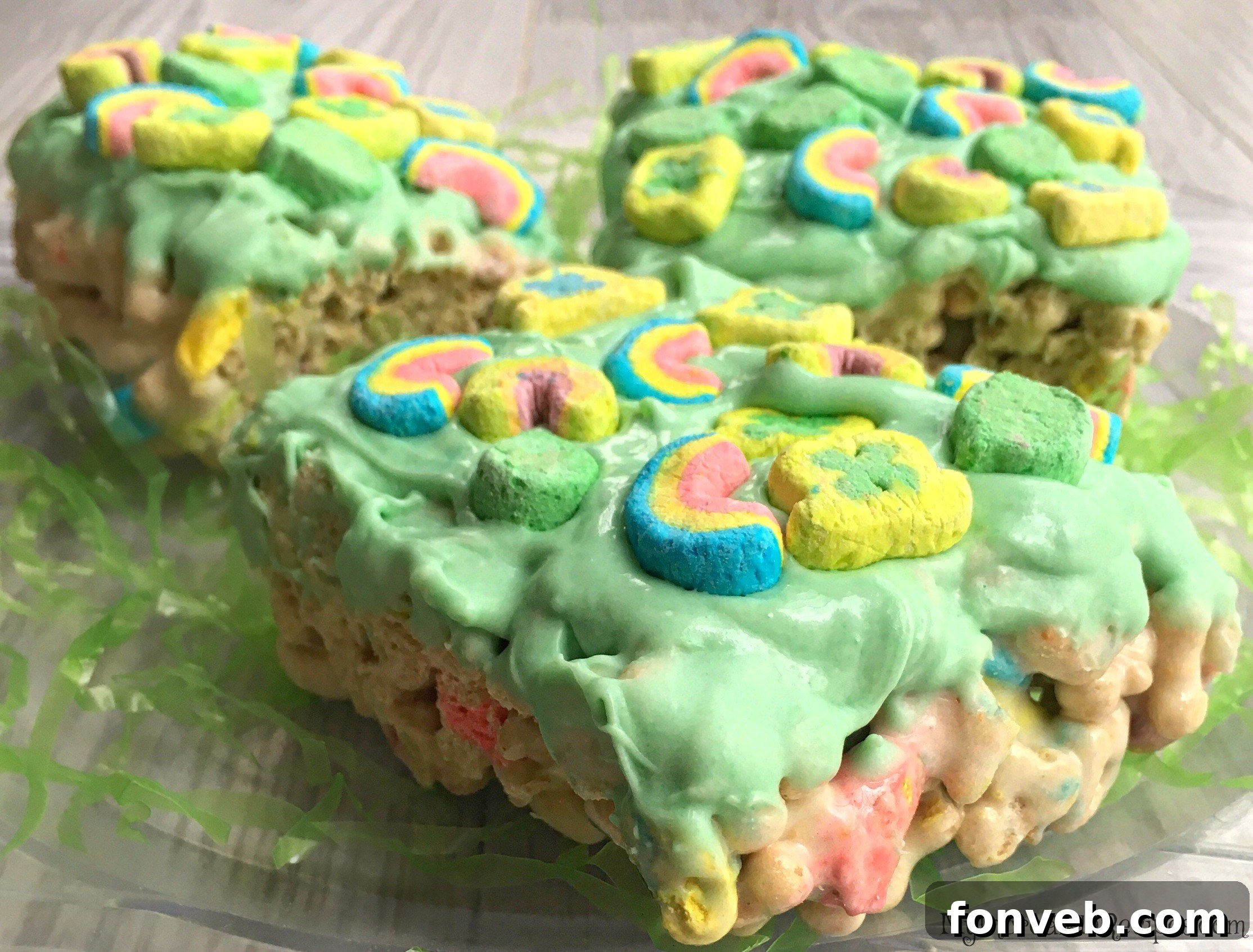 Colorful Lucky Charms Cereal Bars stacked on a white plate, showcasing their vibrant marshmallows.