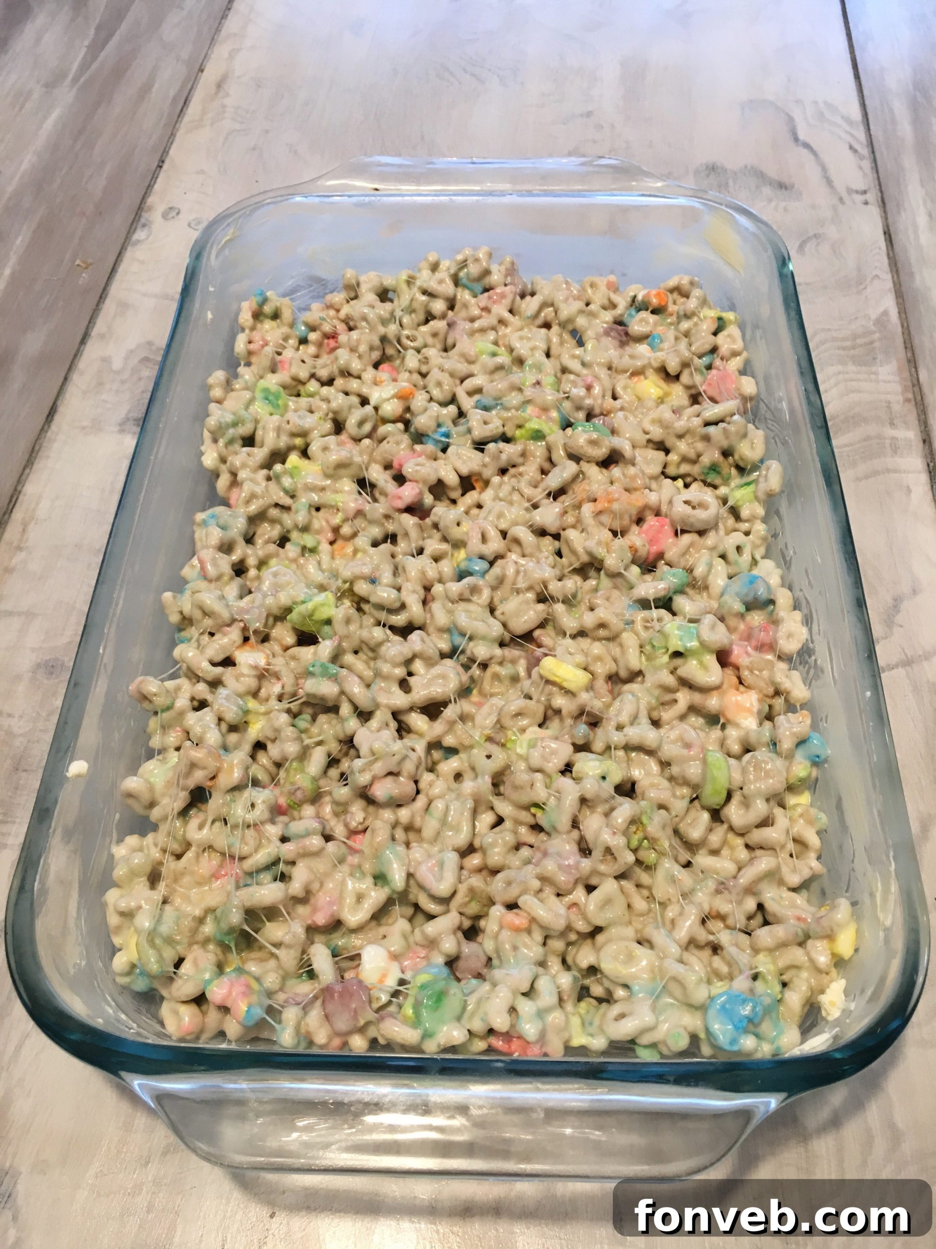 A bowl of Lucky Charms cereal, a bag of marshmallows, and a stick of butter, representing the simple ingredients.