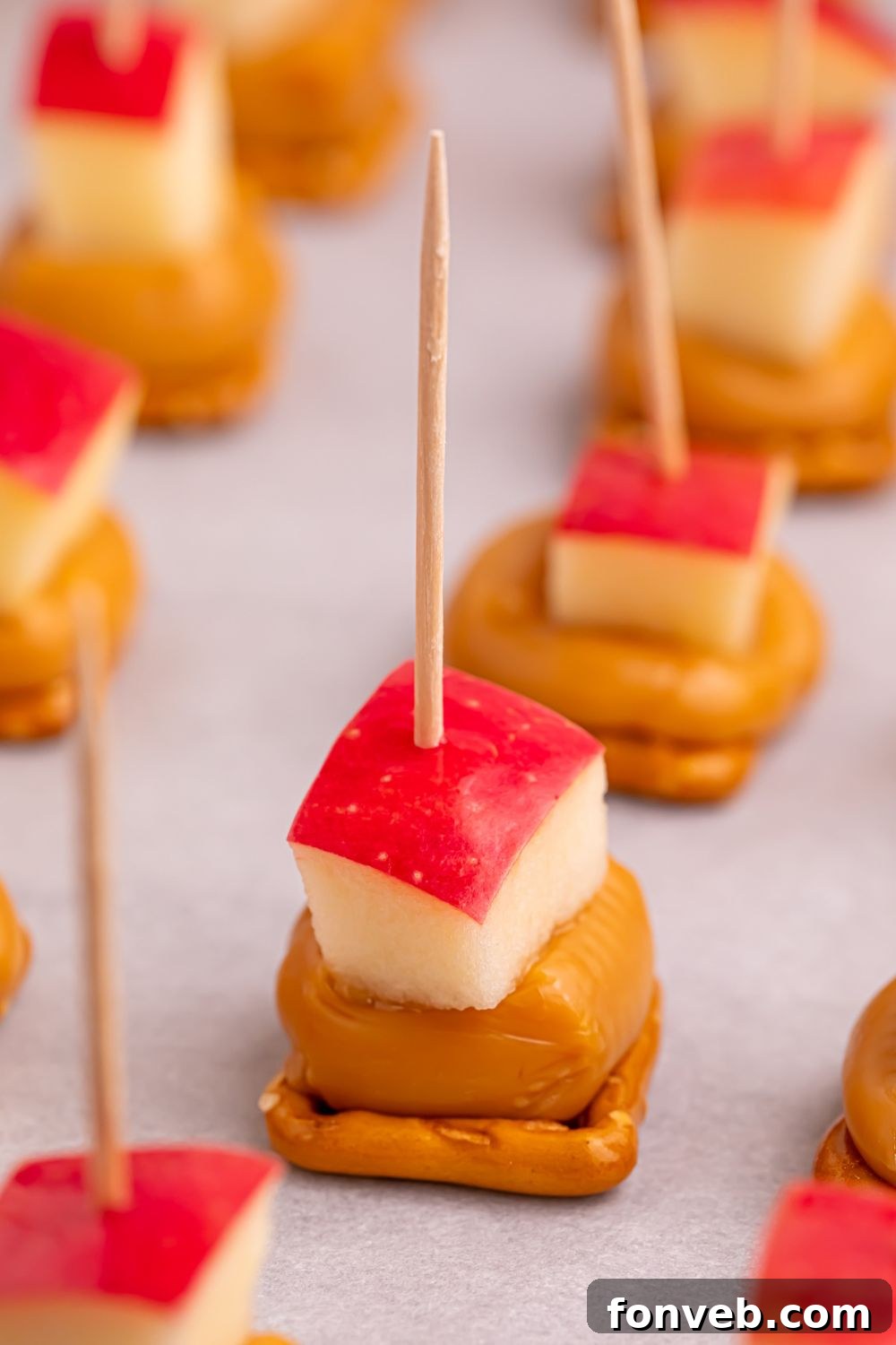 Caramel Apple Pretzel Bites on a parchment lined tray on table 