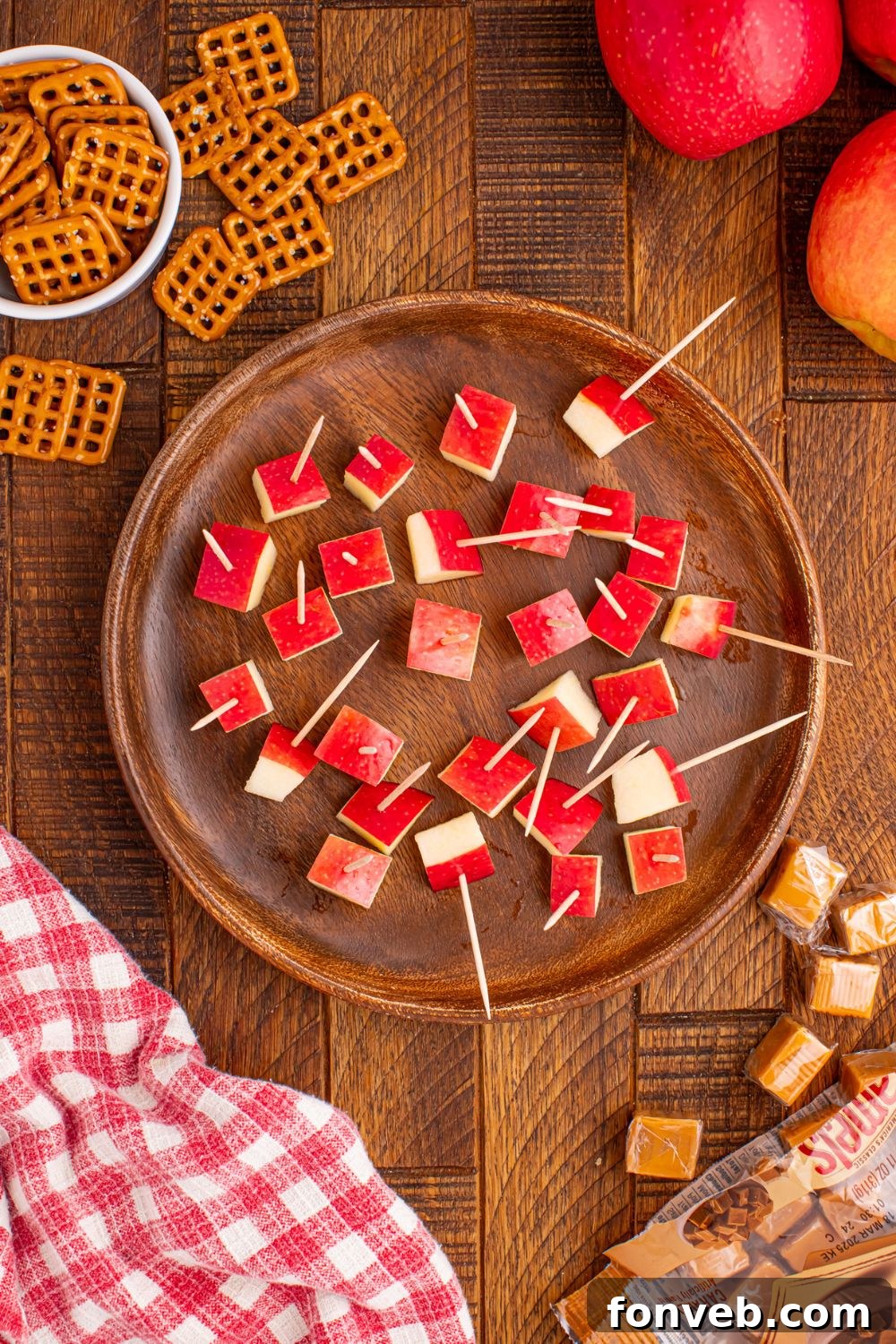 diced apples with pretzels in them sitting in a bowl on table 
