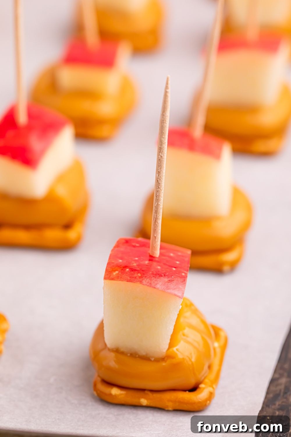 close up of caramel apple pretzel bites on cookie tray 