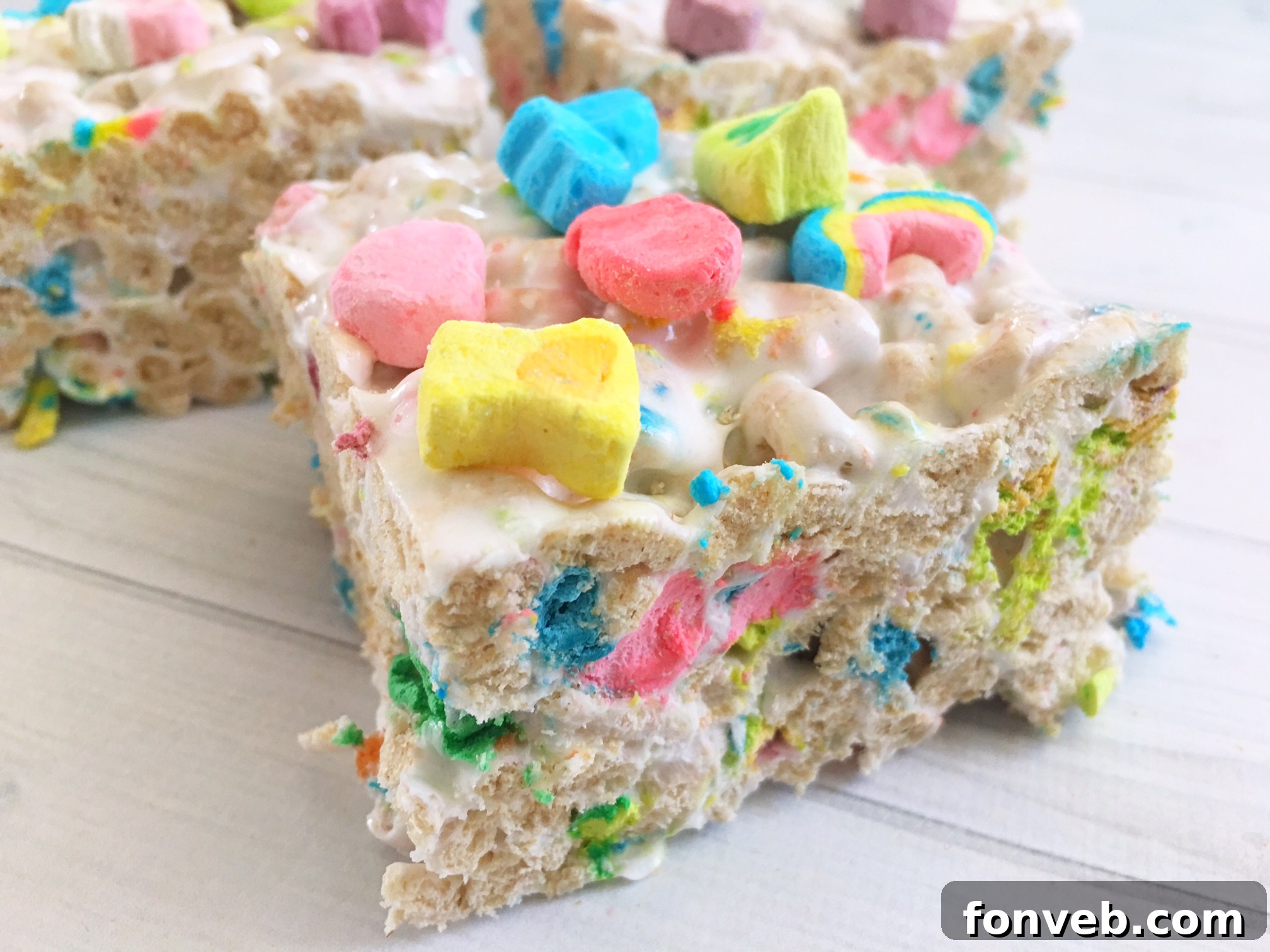 Vibrant green Lucky Charms Krispy Treats, showcasing colorful marshmallows, cut into perfect squares.