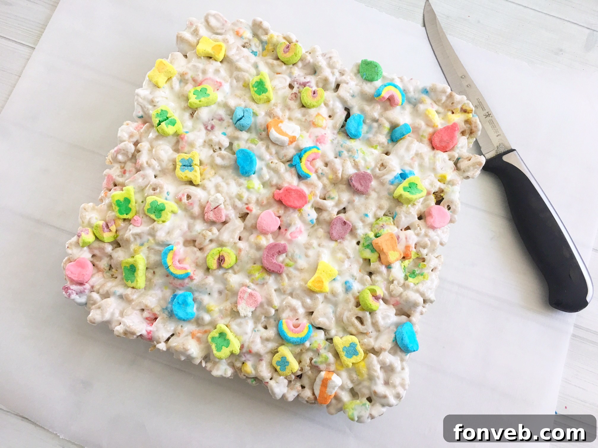Overhead shot of freshly made Lucky Charms Krispy Treats cooling in a baking dish, with vibrant colors.