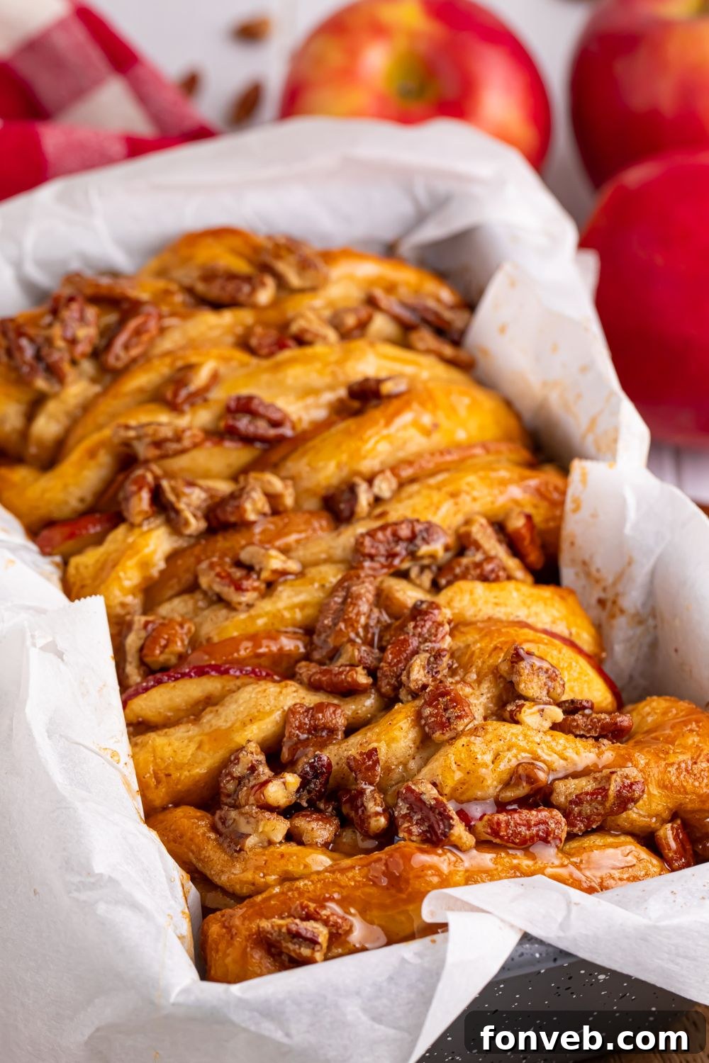 Apple Pie Monkey Bread 12 Apple Pie Pull Apart Bread in a pan with parchment paper in it sitting on a table