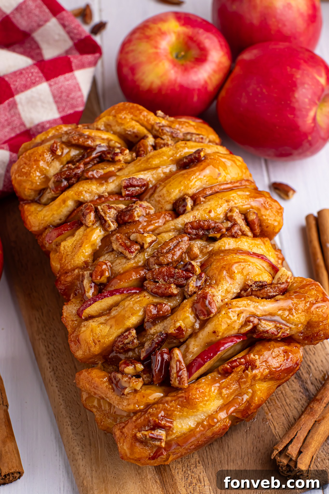 Apple Pie Monkey Bread 19 Apple Pie Pull Apart Bread in a pan sitting on table topped with nuts and caramel sauce