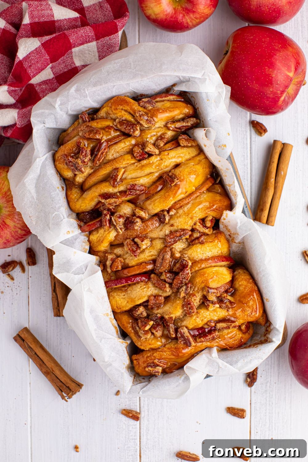 Apple Pie Monkey Bread 4 Apple Pie Pull Apart Bread in the loaf pan sitting on table with spices and apples around it on table