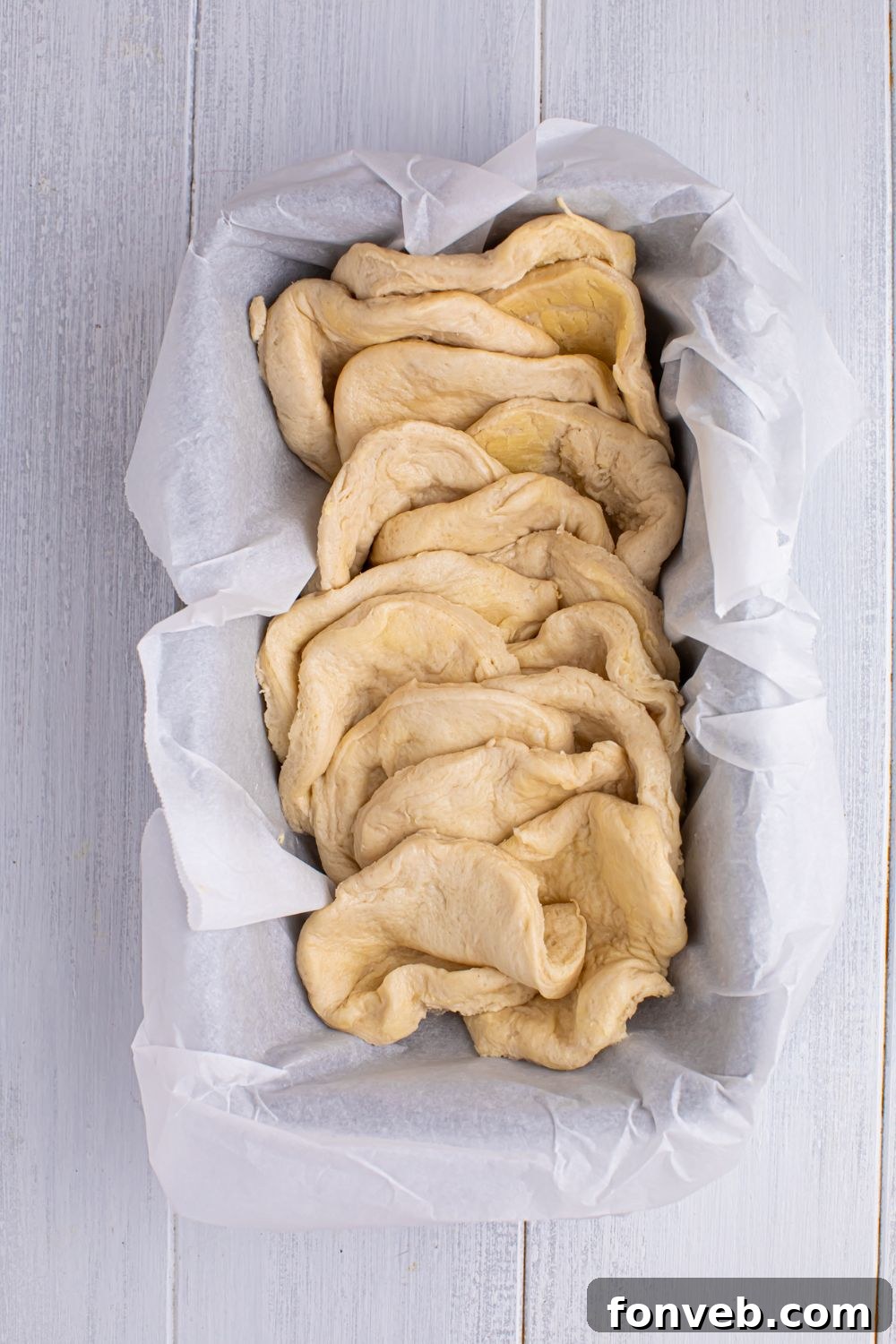 Apple Pie Monkey Bread 9 pulled apart biscuit dough in a loaf pan for making the Apple Pie Pull Apart Bread