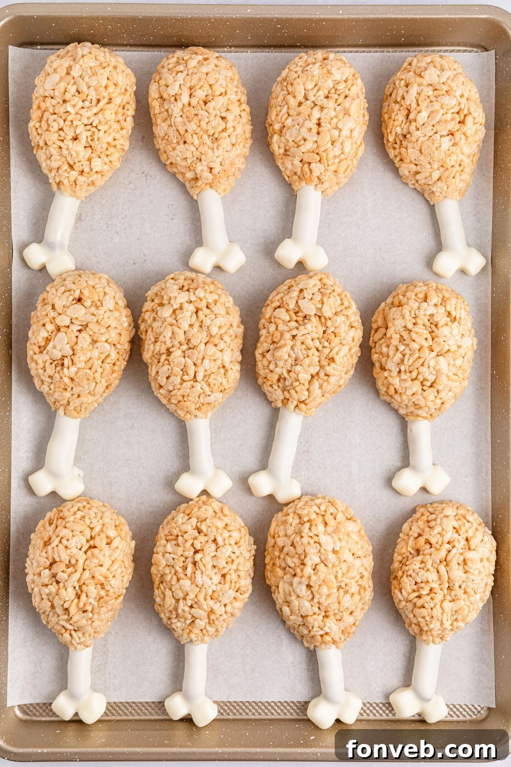 Festive Rice Krispie Drumsticks 11 An overhead shot of several Rice Krispie Treat Turkey Legs neatly arranged on a baking tray, spaced out to set perfectly.