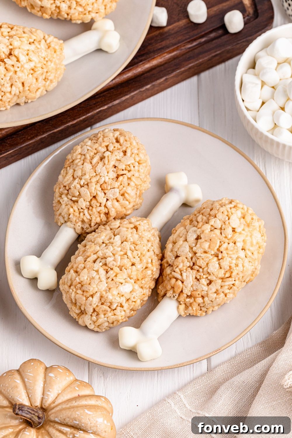 Festive Rice Krispie Drumsticks 12 An inviting overhead view of Rice Krispie Turkey Legs arranged on a plate, with a bowl of mini marshmallows placed enticingly to the side.