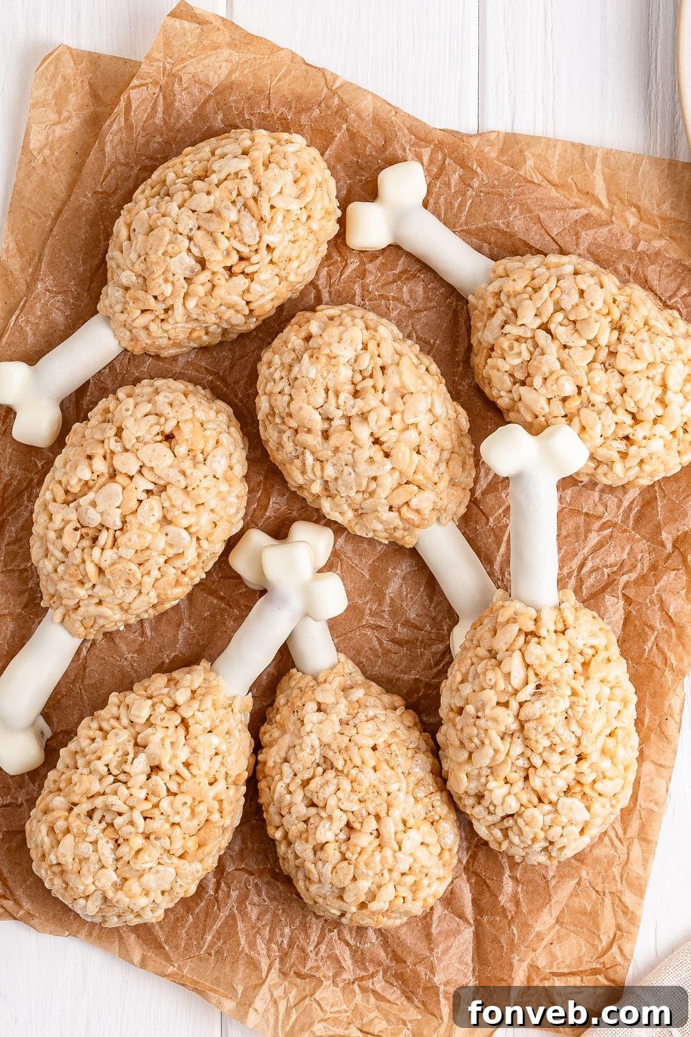 Festive Rice Krispie Drumsticks 16 An array of Rice Krispie Treat Turkey Legs thoughtfully spread out on parchment paper, resting on a clean white table, ready for their final set.