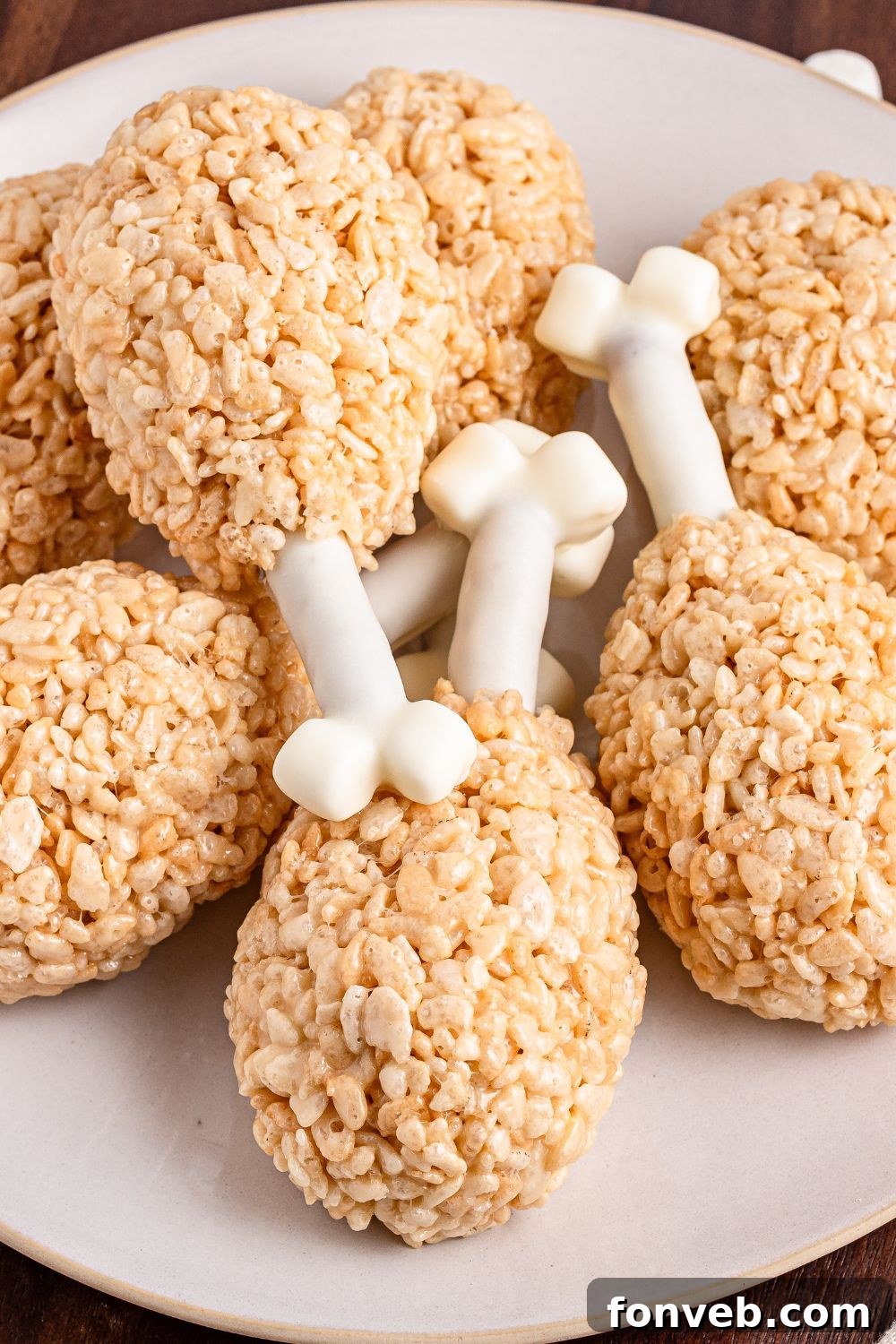 Festive Rice Krispie Drumsticks 4 A beautiful platter filled with Rice Krispie Treat Turkey Legs, artfully stacked and overlapping, showcasing their appealing texture and shape.
