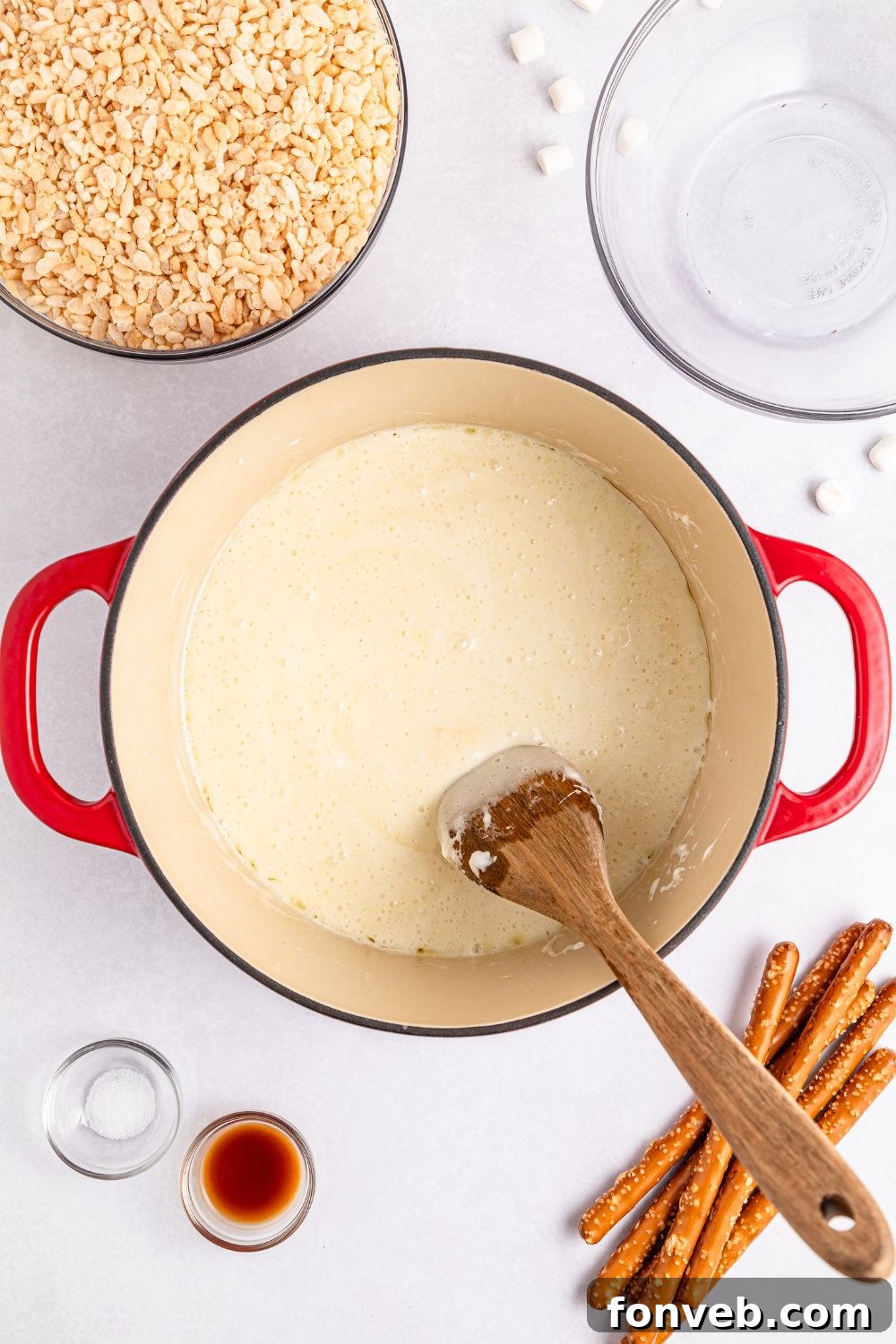 Festive Rice Krispie Drumsticks 10 A marshmallow mixture being gently melted and stirred in a stockpot, creating a smooth and gooey base for the Rice Krispie treats.