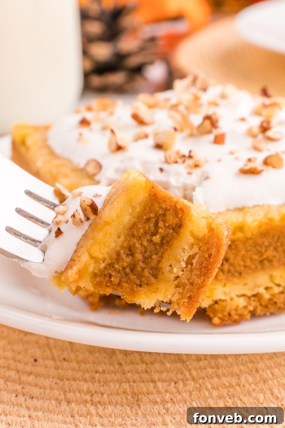 Harvest Pumpkin Pie Delight 13 A delicious slice of Pumpkin Pie Cake on a plate, with a fork gently holding a small bite, inviting the viewer to taste.