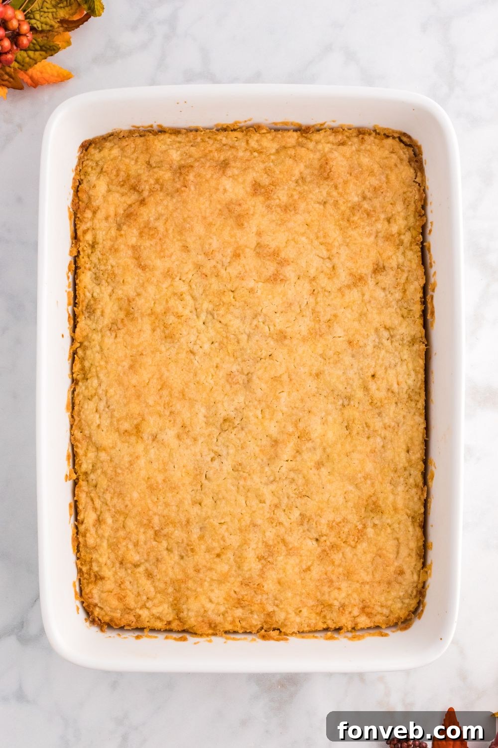 Harvest Pumpkin Pie Delight 9 An overhead view of the assembled Pumpkin Pie Cake in a baking pan, with the crumb topping evenly distributed, ready to be placed in the oven.