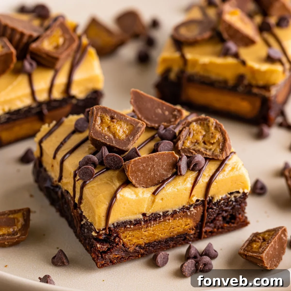 Perfectly cut Reese's Stuffed Brownies arranged on a serving tray, adorned with extra candy pieces