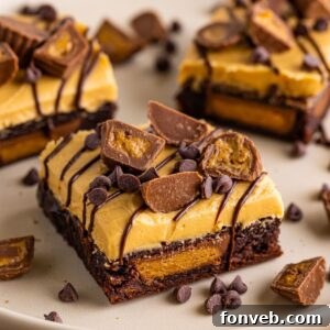 Reeses Stuffed Brownies cut into squares and placed on a tray with candy sprinkled around the plate