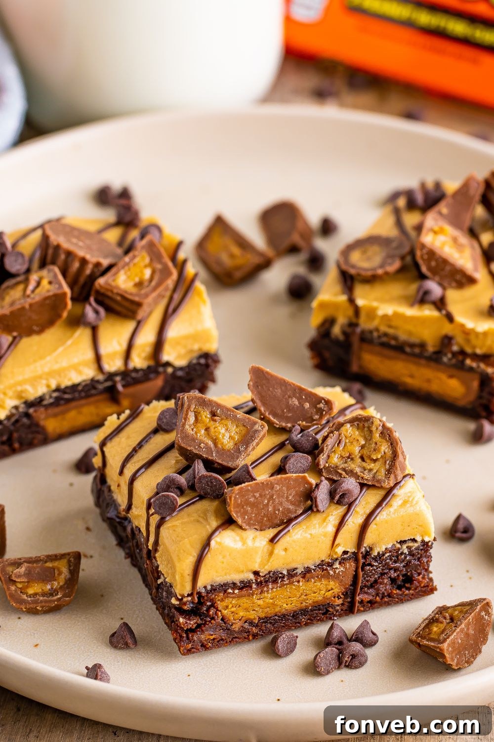 A close-up of Reese's Stuffed Brownies, neatly sliced into squares and artfully arranged on a round plate, ready to be served